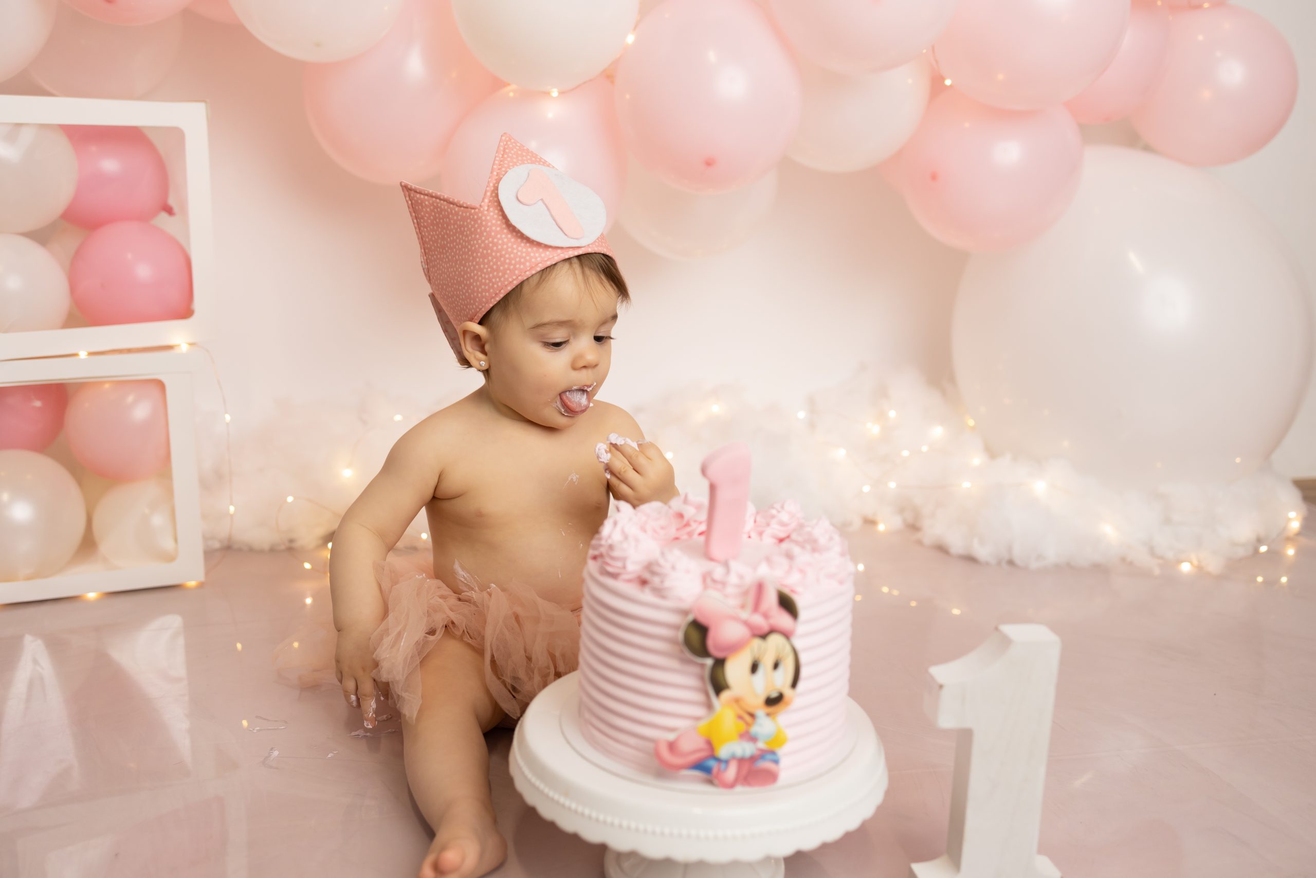 Reportaje de fotos para celebrar el primer año de tu peque en estudio Granollers, fotos con pastel rosa de la minnie